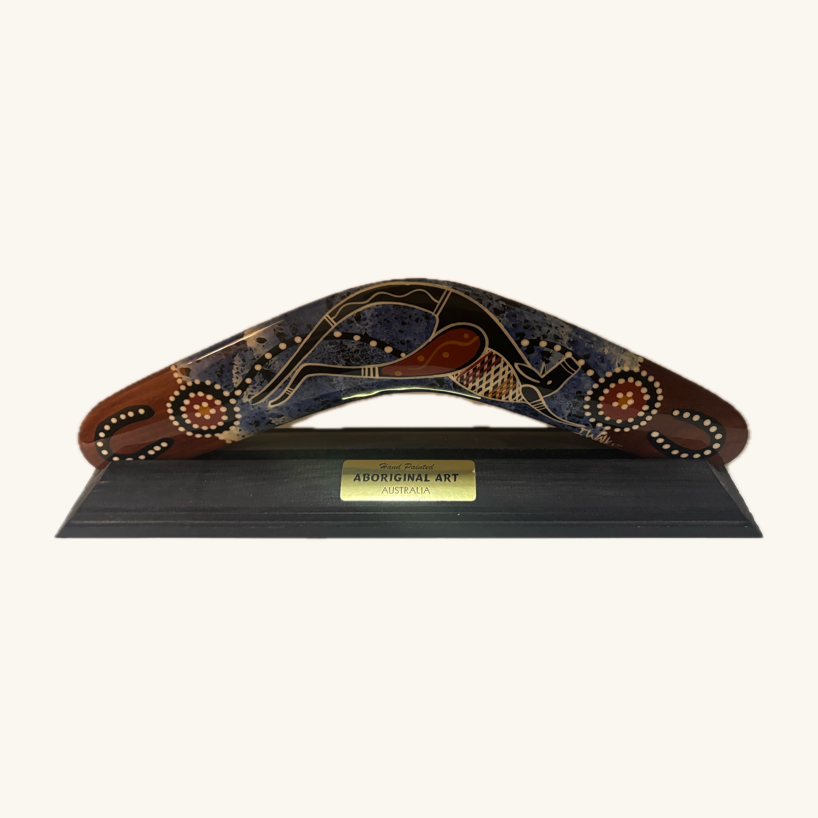 Hand-painted Aboriginal art boomerang on display stand